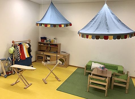 Dieses Bild zeigt unser Rollenspielzimmer mit Puppenküche und vielfältigen Verkleidungsmöglichkeiten